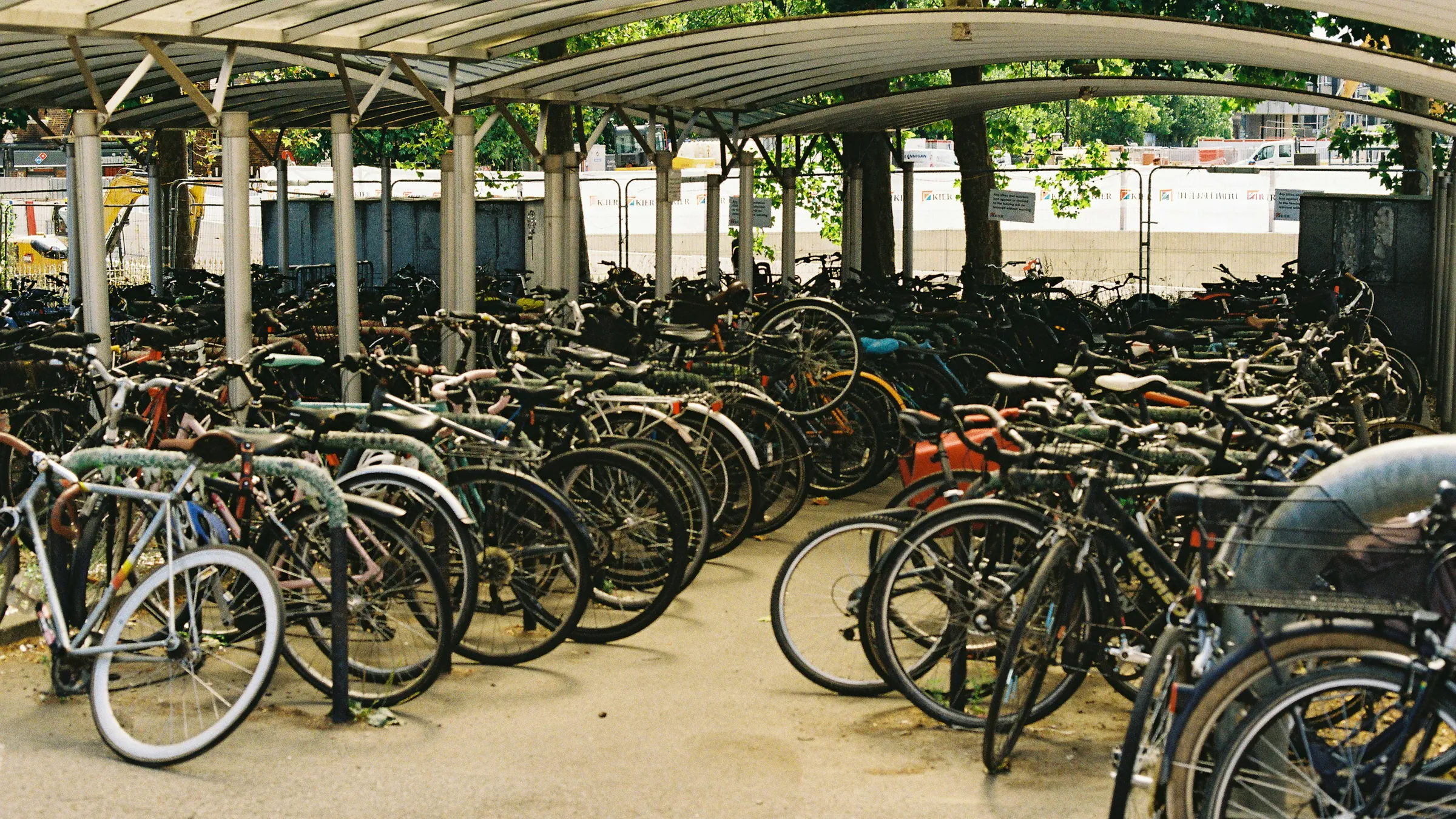 Hundredvis af cykler parkeret side om side under et langt halvtag